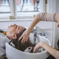 Hairdresser washing client's hair