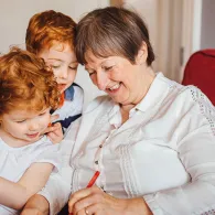 Adult and children writing together
